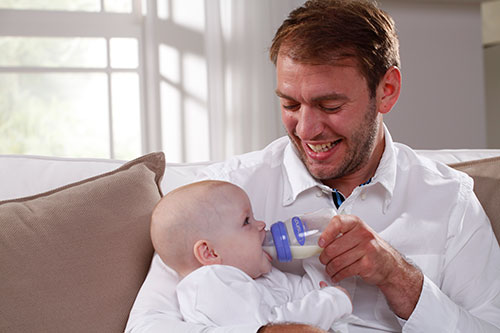 Feeding Bottle With NaturalWave™ Teat Used To Feed Baby By Dad